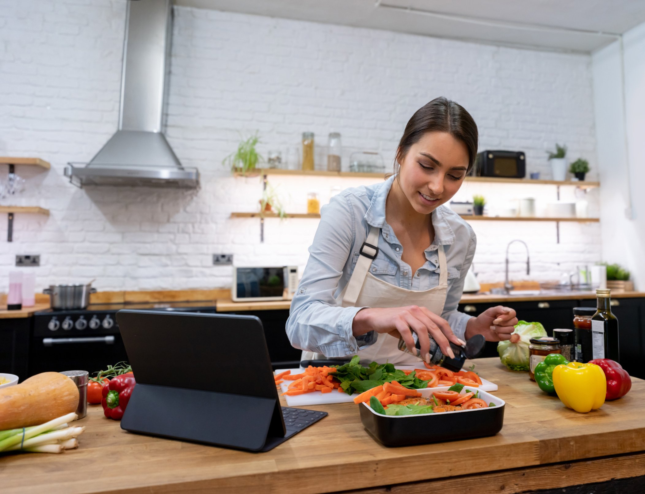 Woman cooking dinner following an online recipe